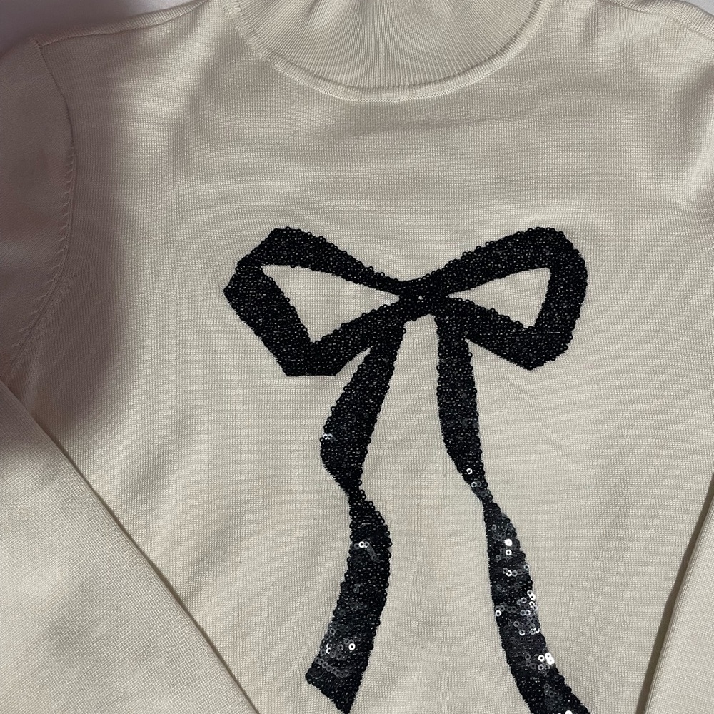 Cream colored with Black sequined Bow light weight sweater Large
New York & Co